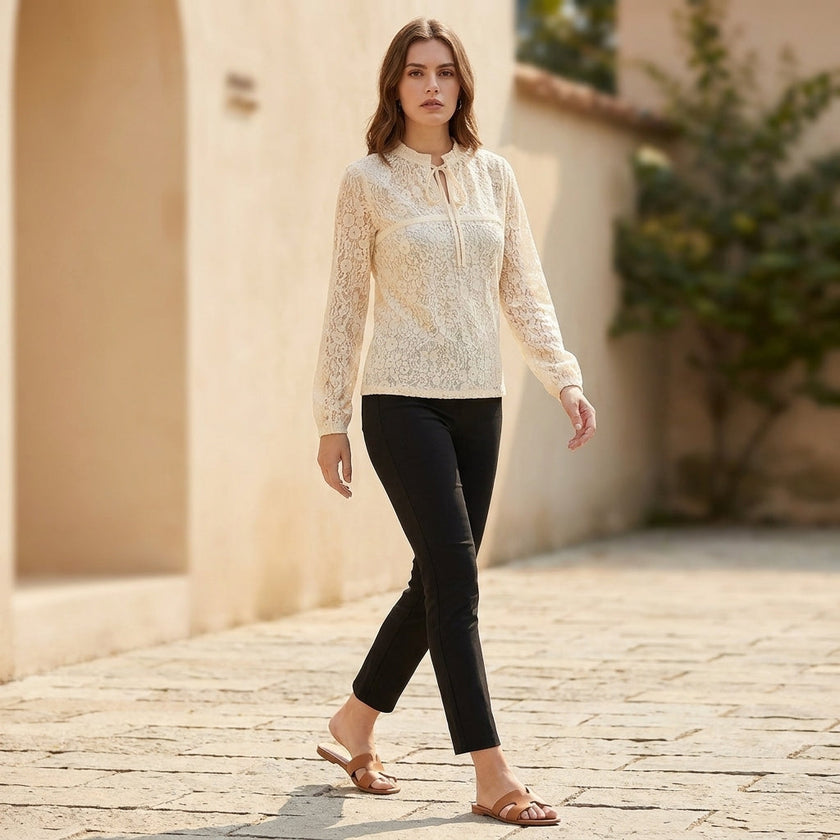 FJØRNA fitted sheer lace blouse with ruffled tie-neck and floral detailing, styled as part of a casual women's outfit.