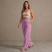 Women’s linen summer trousers by FJØRNA with pockets and drawstring, styled casually in a bright outdoor setting.
