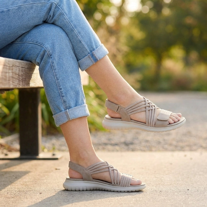 FJØRNA orthopedic criss-cross strappy sandals for women with adjustable straps, worn outdoors on a woman’s feet.