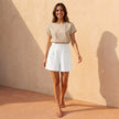 Women’s linen summer shorts by FJØRNA with pockets, shown styled casually on a model in a sunny outdoor setting.