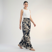 Women’s summer trousers by FJØRNA, cotton ruched design, relaxed fit, styled with casual top in a bright outdoor setting.