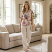 FJØRNA women's floral summer blouse with short sleeves, casual lifestyle shot showing lightweight fabric and vibrant print.