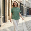 FJØRNA summer blouse for women with high neck and short sleeves, stylish casual top worn outdoors in a lifestyle setting.