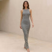 FJØRNA ribbed bodycon high neck sleeveless maxi dress worn by a woman outdoors, showcasing stylish, fitted evening wear.