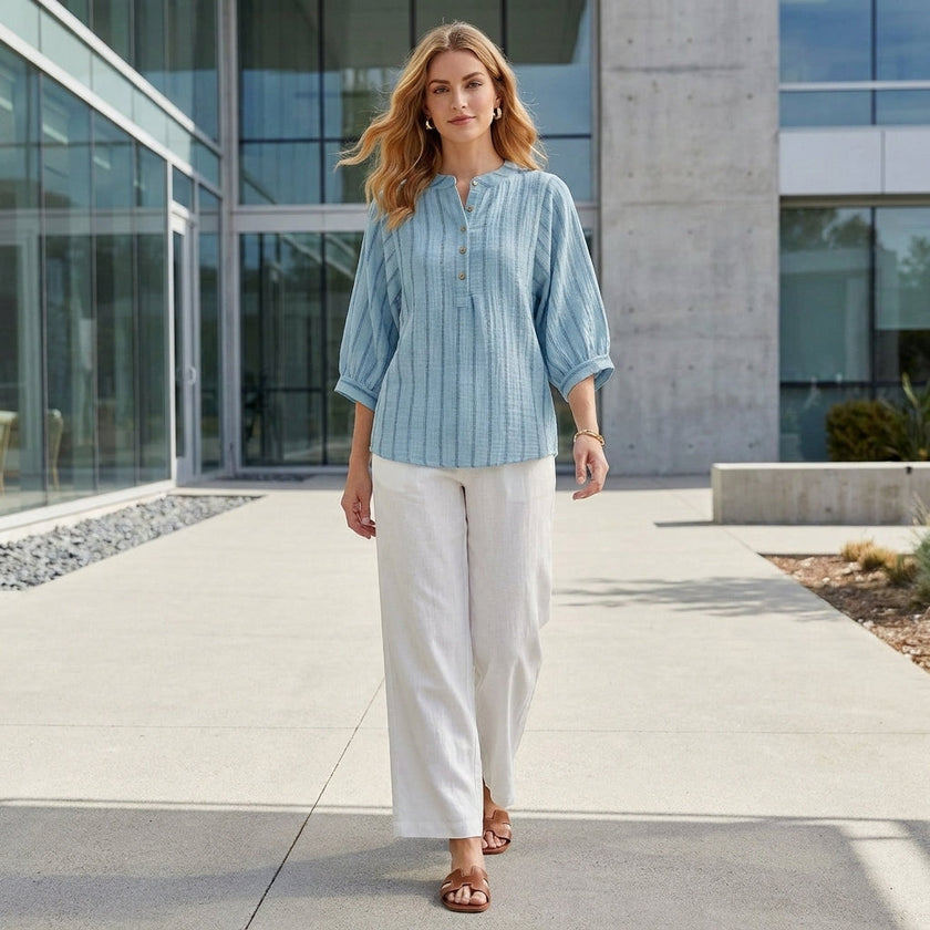 FJØRNA women's striped linen summer blouse with button front, styled in a casual outdoor setting.