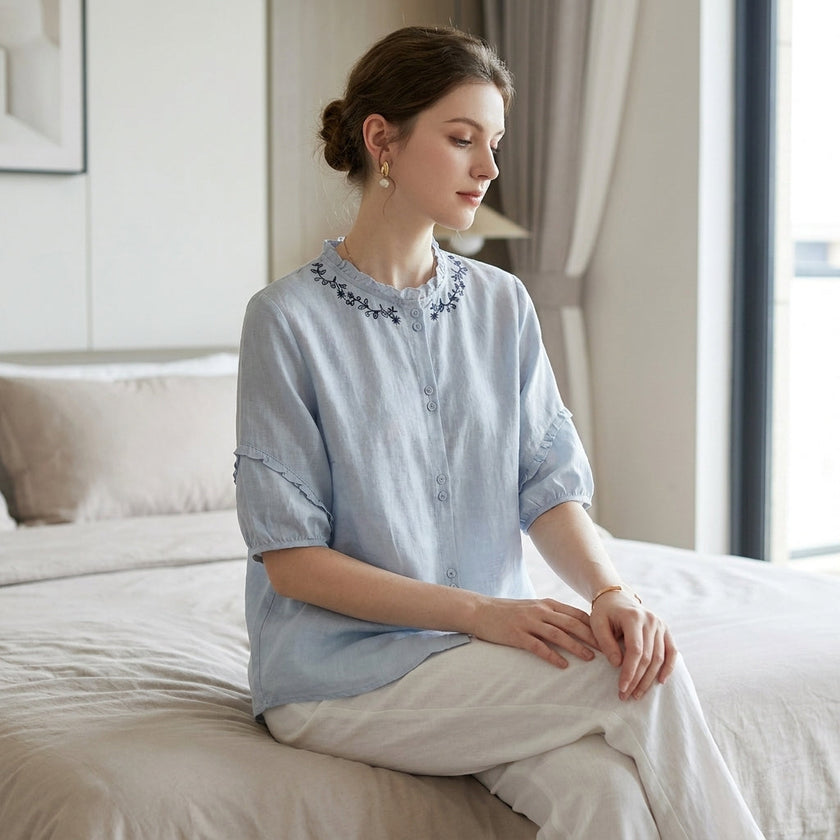 FJØRNA women's summer linen blouse with ruffle details, styled as a casual top in a relaxed lifestyle setting.