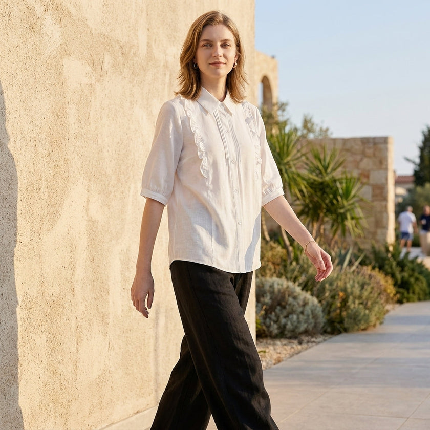FJØRNA summer women's denim blouse with ruffle details, styled casually with rolled-up sleeves and a relaxed fit.