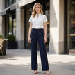 FJØRNA women's summer blouse with short sleeves and stylish cut-out design, worn in a casual outdoor setting.