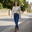 FJØRNA women's summer V-neck denim blouse with ruffle details, styled in a casual outdoor setting.