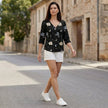 FJØRNA women's summer floral V-neck blouse with denim fabric and button front, styled as a casual top in a lifestyle setting.