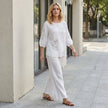 FJØRNA summer floral blouse for women with puff sleeves, styled casually with a relaxed fit and vibrant floral pattern.