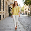 FJØRNA women's summer linen blouse, flowy and lightweight, worn by a woman outdoors in a casual, stylish outfit.
