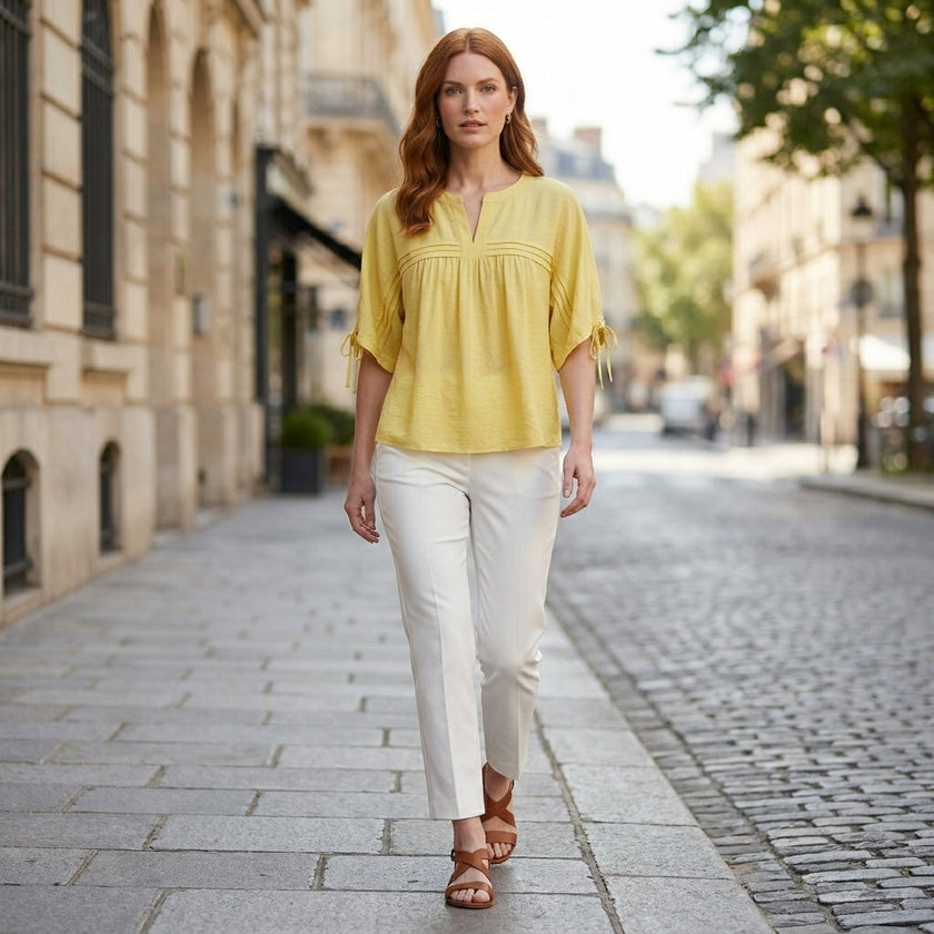 FJØRNA women's summer linen blouse, flowy and lightweight, worn by a woman outdoors in a casual, stylish outfit.