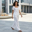 FJØRNA Coastal Breeze relaxed top and wide-leg pant 2-piece set worn by a woman in a casual seaside setting.