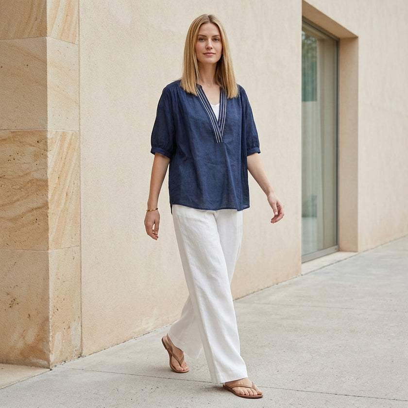 FJØRNA summer women's blouse with V-neck and puff sleeves, styled casually with a relaxed fit and lightweight fabric.