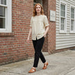 FJØRNA women's summer blouse with puff sleeves, denim fabric, and button front, styled casually in a lifestyle setting.