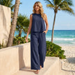 FJØRNA sunlit sleeveless two-piece set with flowing wide-leg pants, perfect for warm weather, styled in a casual outdoor setting.