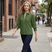 Women’s summer blouse by FJØRNA with long sleeves and smocked design, worn casually outdoors in a lifestyle setting.