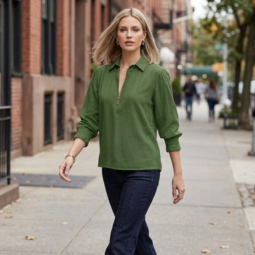 Women’s summer blouse by FJØRNA with long sleeves and smocked design, worn casually outdoors in a lifestyle setting.
