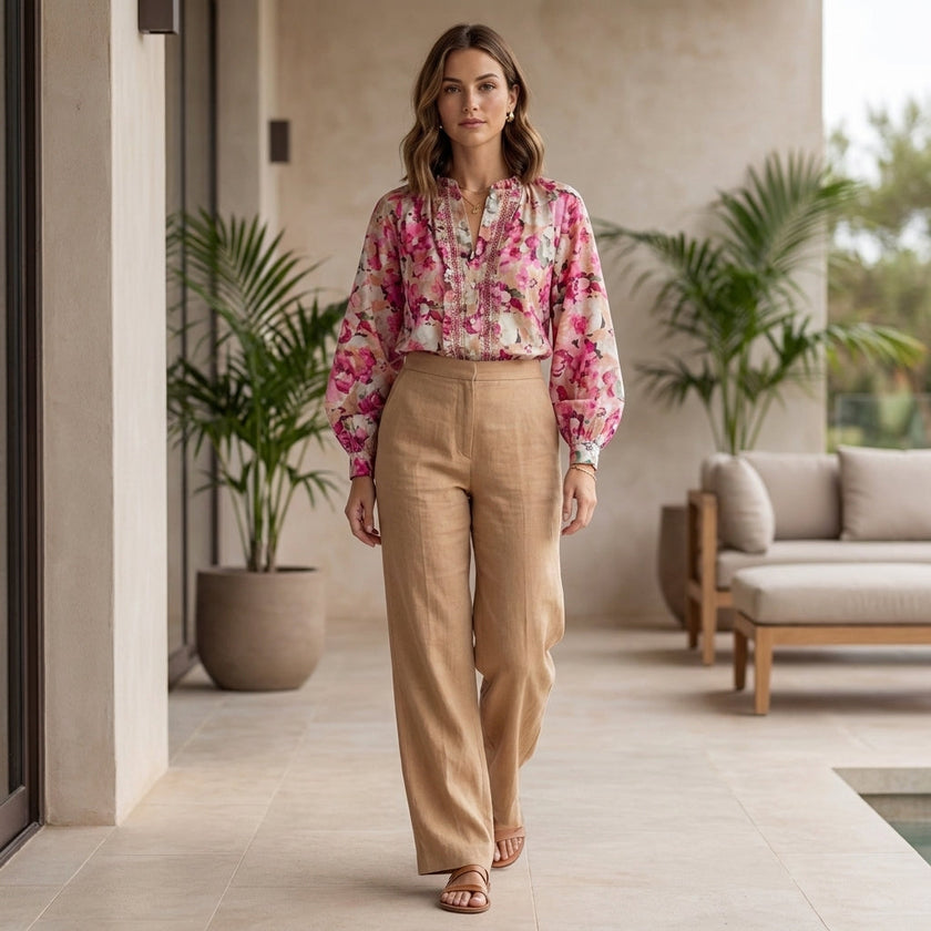 FJØRNA women's floral summer blouse with long sleeves and ruffles, styled with natural outdoor background.