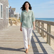 FJØRNA women's summer denim blouse, flowy and stylish, worn casually in a lifestyle setting with natural light.
