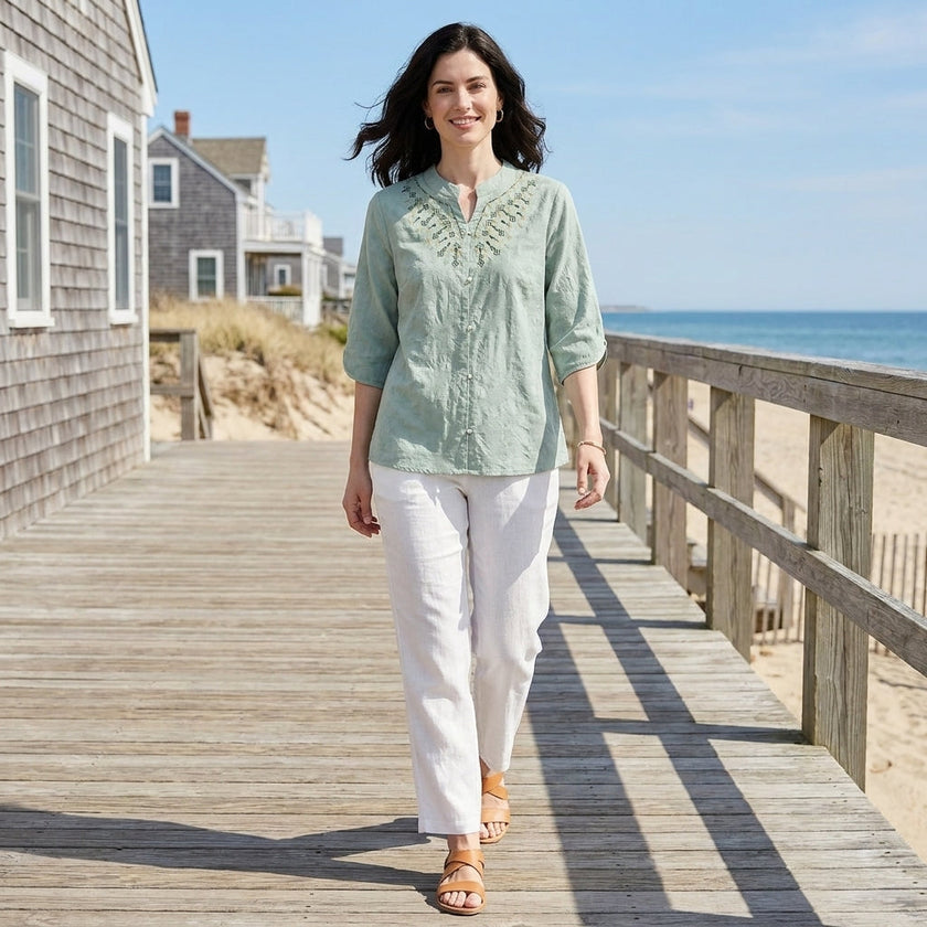 FJØRNA women's summer denim blouse, flowy and stylish, worn casually in a lifestyle setting with natural light.