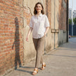 FJØRNA women's summer blouse with puff sleeves, denim fabric, button front, casual style, worn in a relaxed outdoor setting.