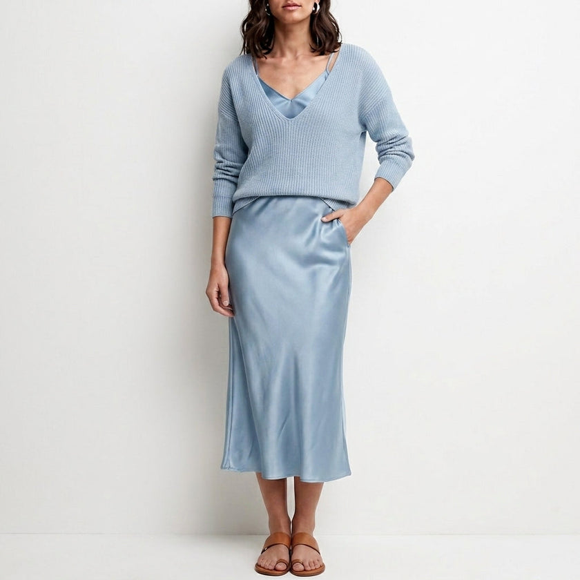 Light blue FJØRNA relaxed V-neck knit top and satin maxi skirt set, featuring a cozy knit top and flowing satin skirt.