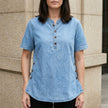 Light blue FJØRNA women's summer denim top with button front, sleeveless design, and casual fit.