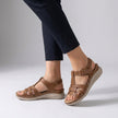 Light brown FJØRNA orthopedic open toe wedge sandals with cross-strap stitching and supportive design.