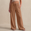 Light brown women's linen summer trousers with pockets and drawstring from FJØRNA, casual and breathable for warm weather.