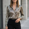 Light gray women's summer blouse with long sleeves and floral print by FJØRNA, shown hanging on a hanger.
