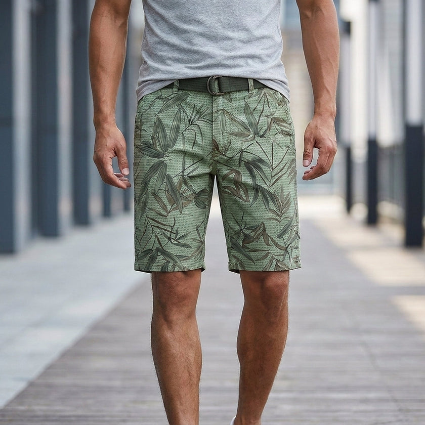 Men's casual work shorts with leaf print in light green, featuring a belt and relaxed fit, by FJØRNA.