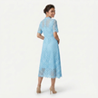 Back view of FJØRNA women's light blue lace midi dress featuring a high neck, elegant silhouette, and refined cutwork detail.