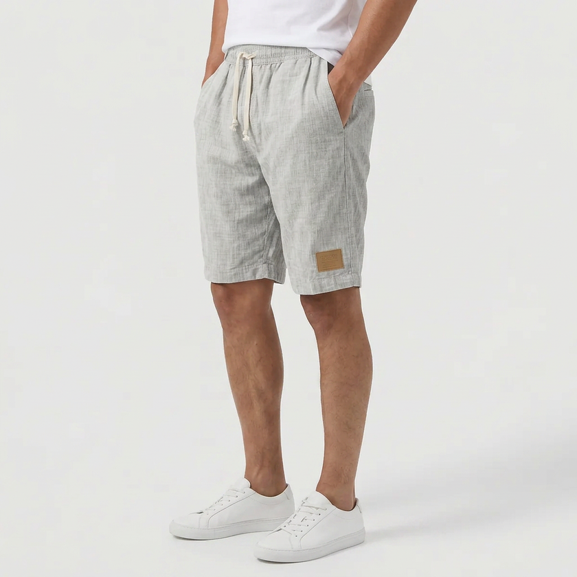 Light gray men's linen shorts with elastic waistband and drawstring, shown from side profile, perfect for summer beachwear.