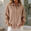 Light brown striped women's button-down blouse with cuffed sleeves by FJØRNA, shown on a model.