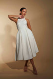 FJØRNA white midi dress with halter neckline, elegant sleeveless design, perfect for summer or formal occasions.