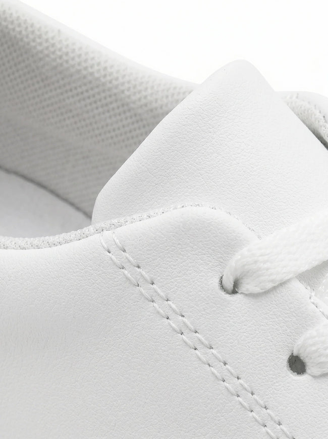 Close-up of men's white slip-on trainers by FJØRNA, showcasing minimalist design and clean casual style.
