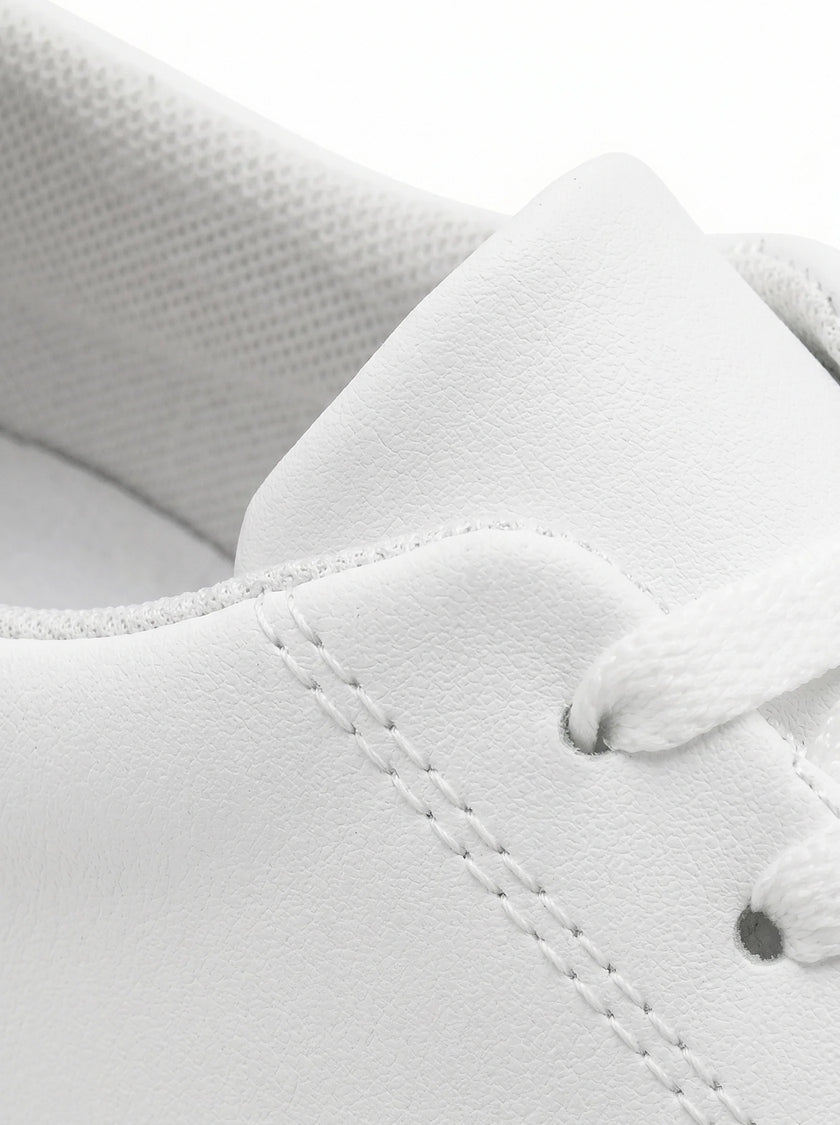 Close-up of men's white slip-on trainers by FJØRNA, showcasing minimalist design and clean casual style.