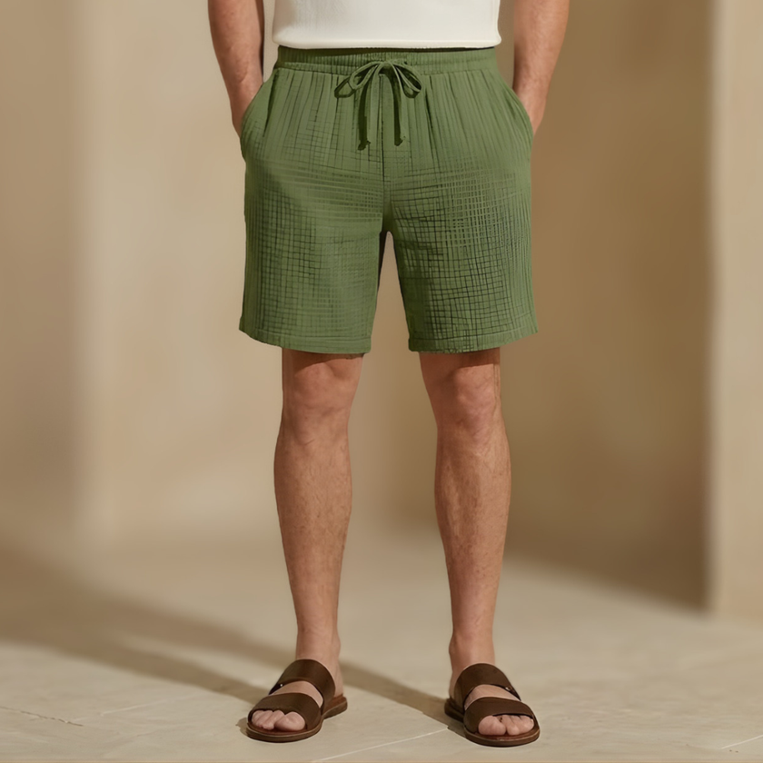 Men's textured summer shorts by FJØRNA with a relaxed fit and drawstring waist, shown in a casual outdoor setting.