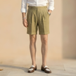 Men's high waist linen shorts by FJØRNA with pleated design and tailored fit, perfect for casual or smart summer wear.