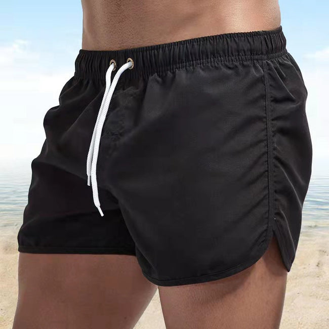 Men's relaxed fit swim shorts with elastic waist and quick-dry fabric by FJØRNA, shown with vibrant blue and green pattern.