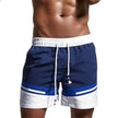 Men's FJØRNA color block swim shorts with elasticated drawstring waist and contrasting panels, suitable for beach or poolside wear.