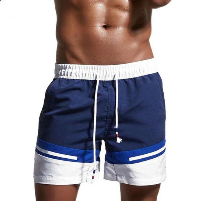 Men's FJØRNA color block swim shorts with elasticated drawstring waist and contrasting panels, suitable for beach or poolside wear.