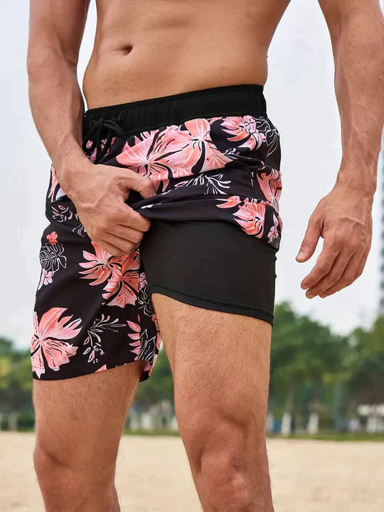 Men's FJØRNA swim shorts with colorful multi-print design and integrated compression liner for comfortable swimming and active wear.