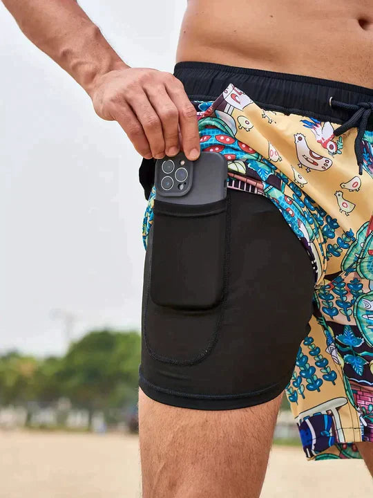 Men's FJØRNA swim shorts with colorful multi-print design and built-in compression liner, perfect for swimming and beachwear.