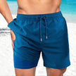 Men's FJØRNA swim shorts with colorful multi-print design and integrated compression liner, perfect for swimming and beach wear.