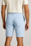 Light blue men's Bermuda shorts by FJØRNA, casual pants with a relaxed fit, shown on a model.