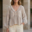 FJØRNA women's summer blouse with V-neck, long sleeves, denim fabric, and ruffle details, in a soft milky white color.