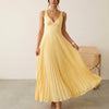 FJØRNA Eileen satin ruched bodice sleeveless maxi dress with pleated skirt, worn by a model showcasing elegant evening wear style.